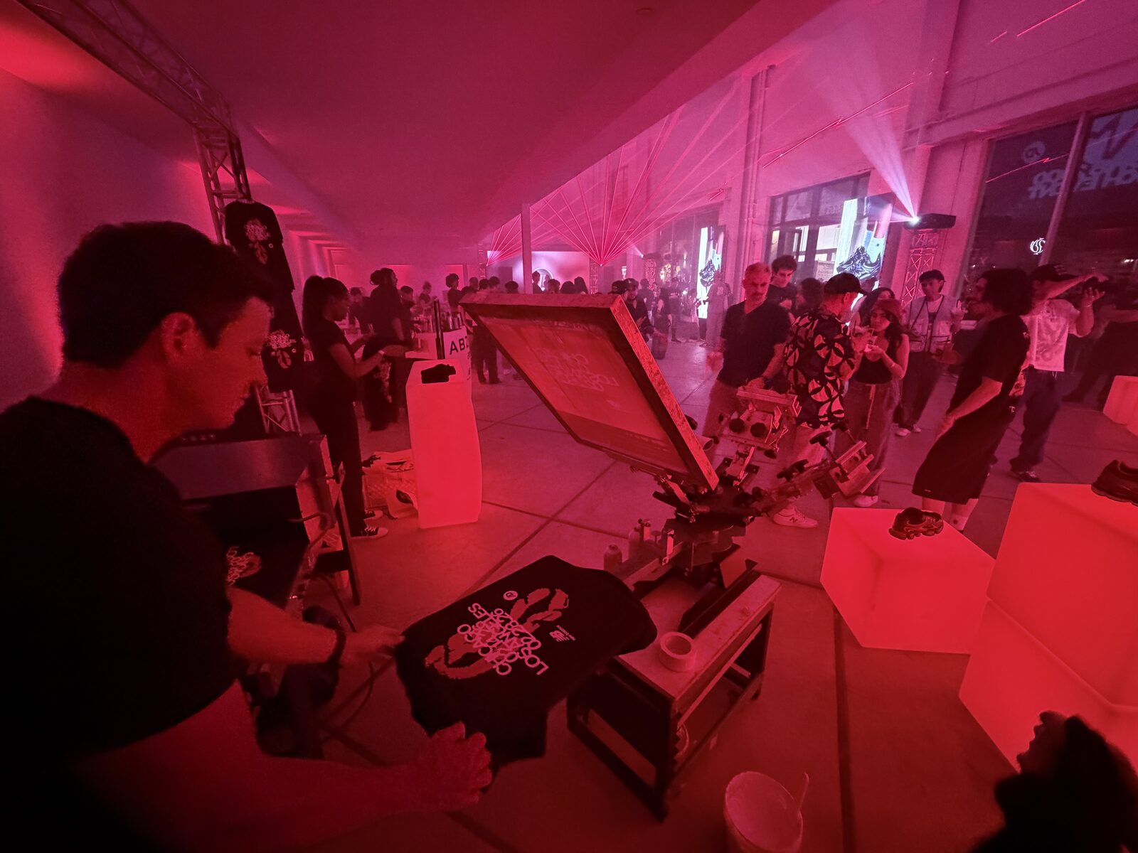 Guest holding up a shirt just printed at a party t-shirt bar